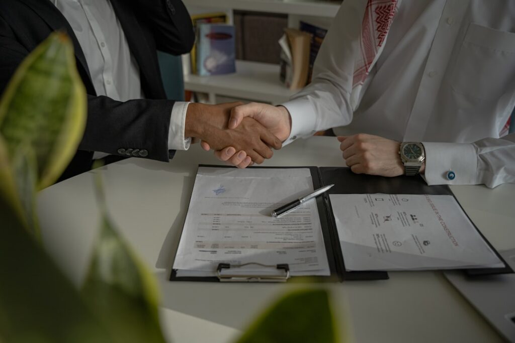 Relieved small business owner shaking hands with an attorney in an office