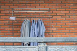 Quiet dry cleaning shop counter with garment racks in summer