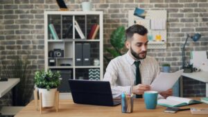 Small business owner reviewing MCA contract paperwork at a desk