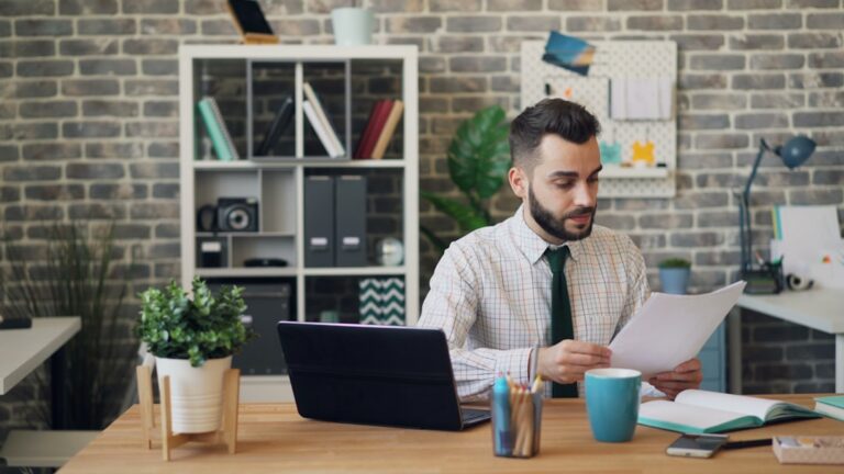 Small business owner reviewing MCA contract paperwork at a desk