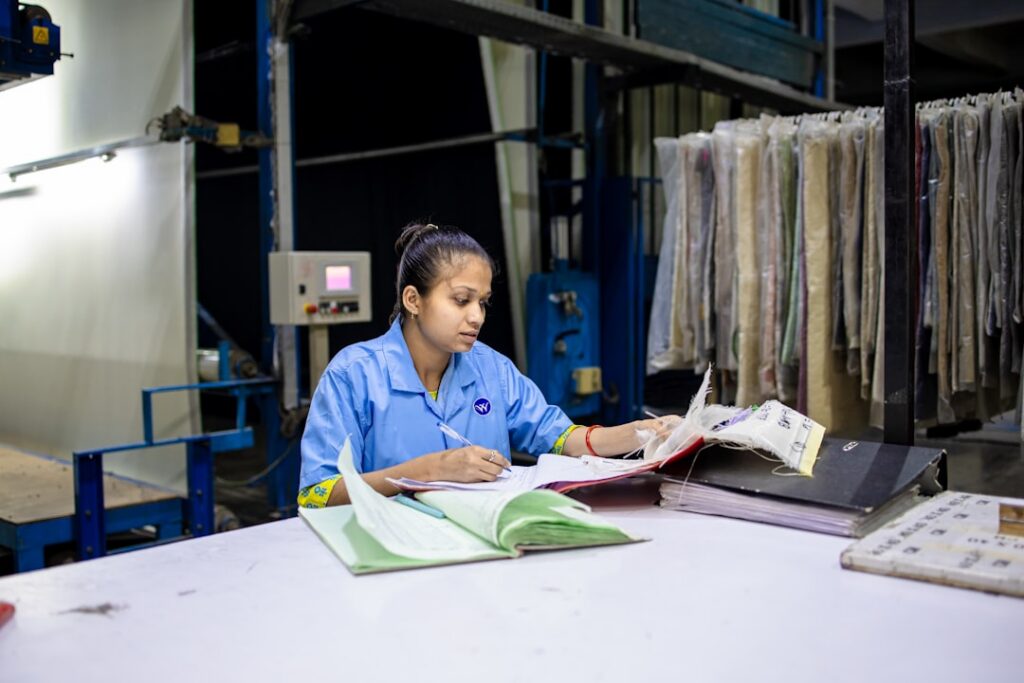 Small manufacturing shop owner reviewing paperwork on the factory floor