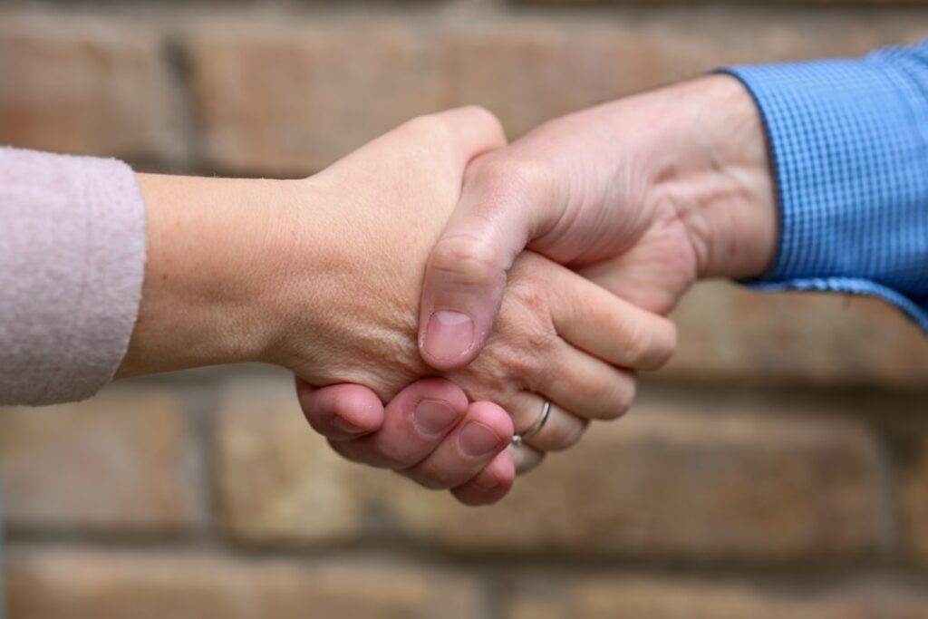 Business owner shaking hands confidently after resolving a debt negotiation