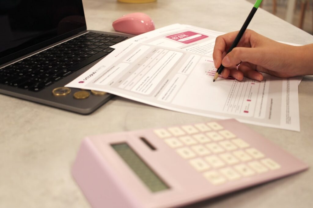 Small business owner reviewing bank statements and a calculator at a desk