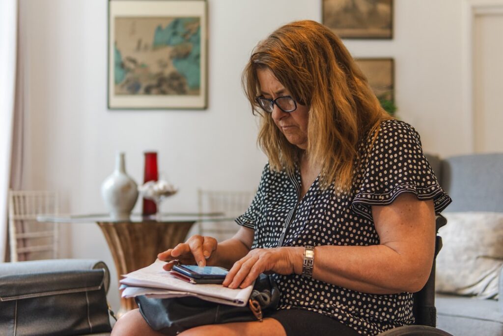 Business owner calculating daily payments with a calculator and receipts