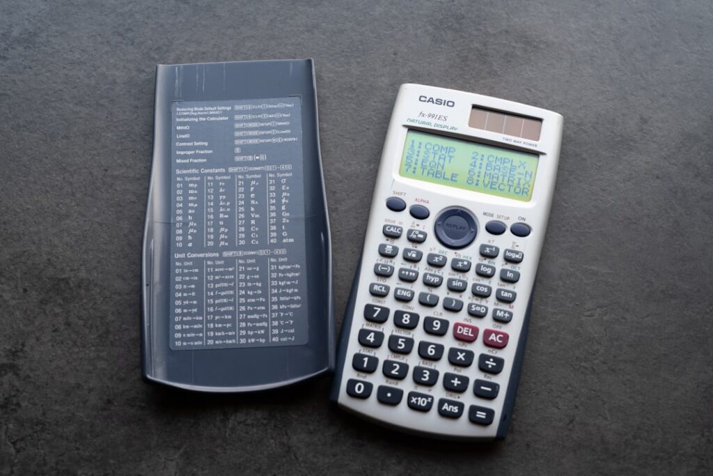 Calculator and factor rate paperwork laid out on a desk