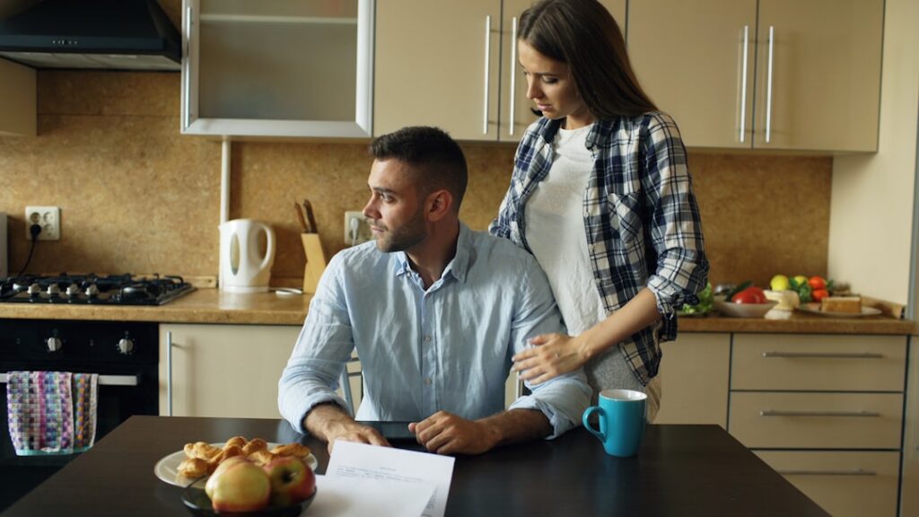 Small business owner reviewing a stack of multiple advance statements at a kitchen table