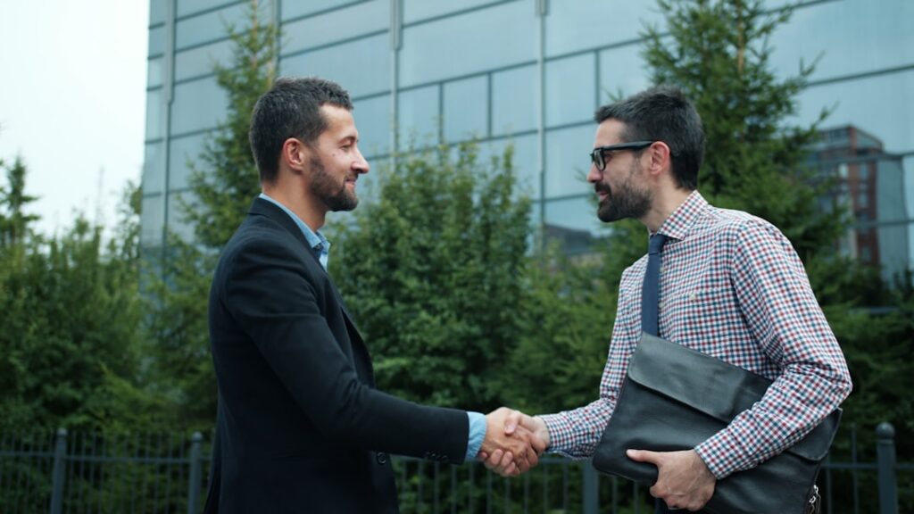 Business owner and advisor shaking hands after reaching a settlement agreement