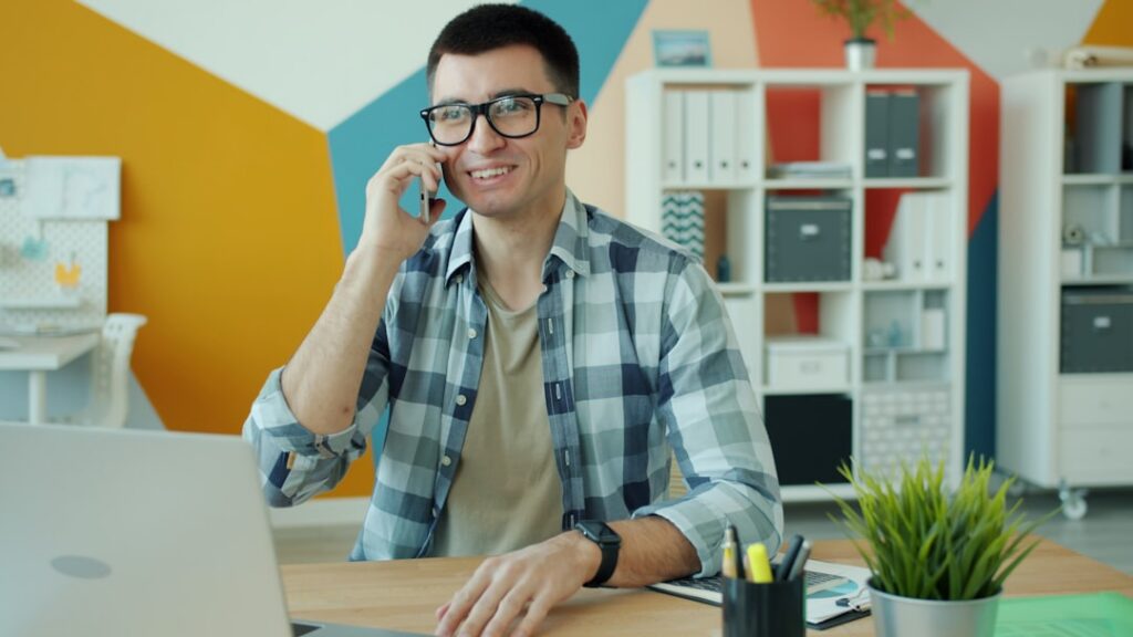 Trucking business owner on a phone call discussing options in a small office