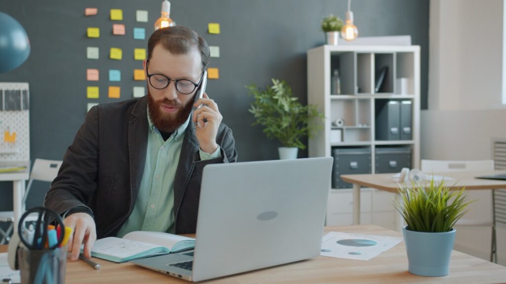 Business owner smiling on a phone call, relieved after discussing debt relief options