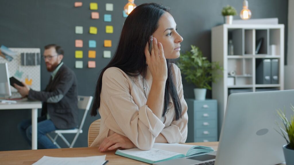 Small business owner on the phone looking relieved while seated in their office