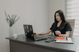 Staffing agency owner reviewing payroll and MCA debt documents at office desk