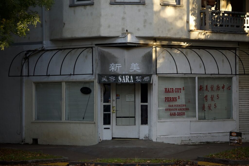 Small business owner boarding up storefront windows ahead of a hurricane
