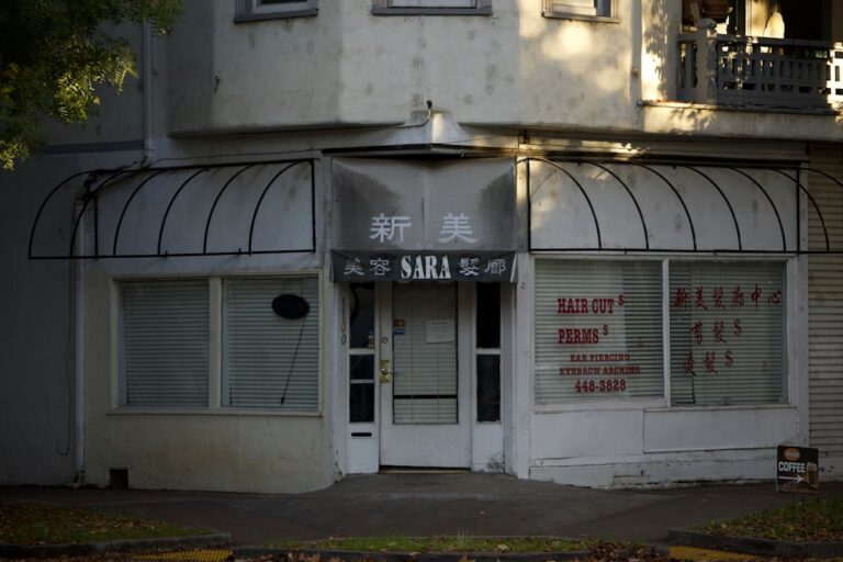 Small business owner boarding up storefront windows ahead of a hurricane