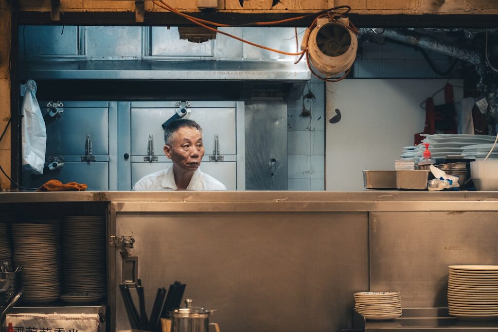 Restaurant owner smiling with relief in the kitchen after a phone call