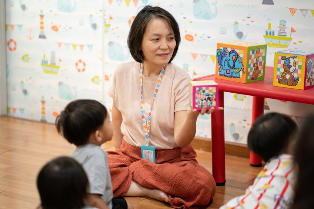Daycare center owner reviewing paperwork while children play nearby