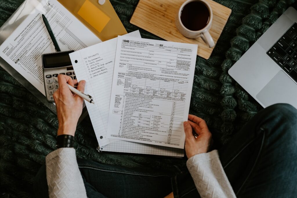Contractor calculating factor rate costs on a merchant cash advance with a calculator and invoices