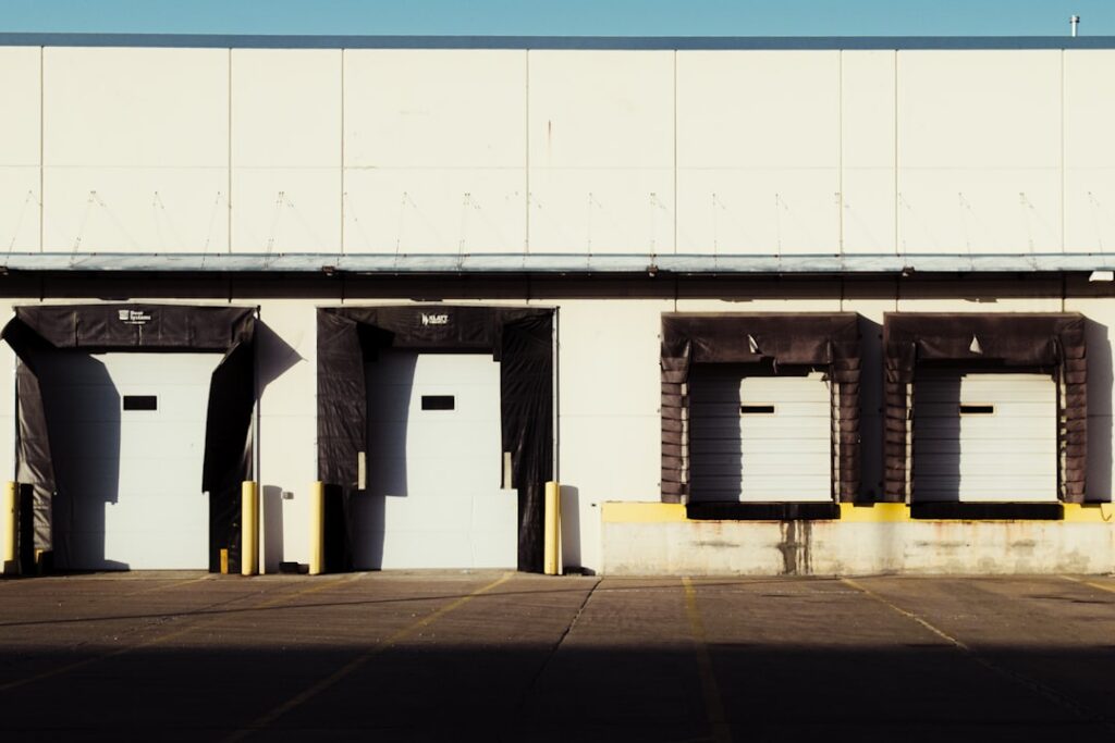 Truck at a loading dock with the driver checking delivery paperwork