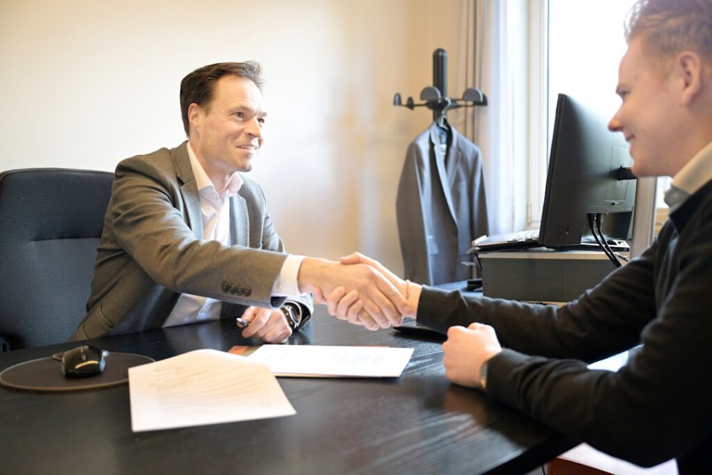 Confident business owner shaking hands with an advisor in a small office