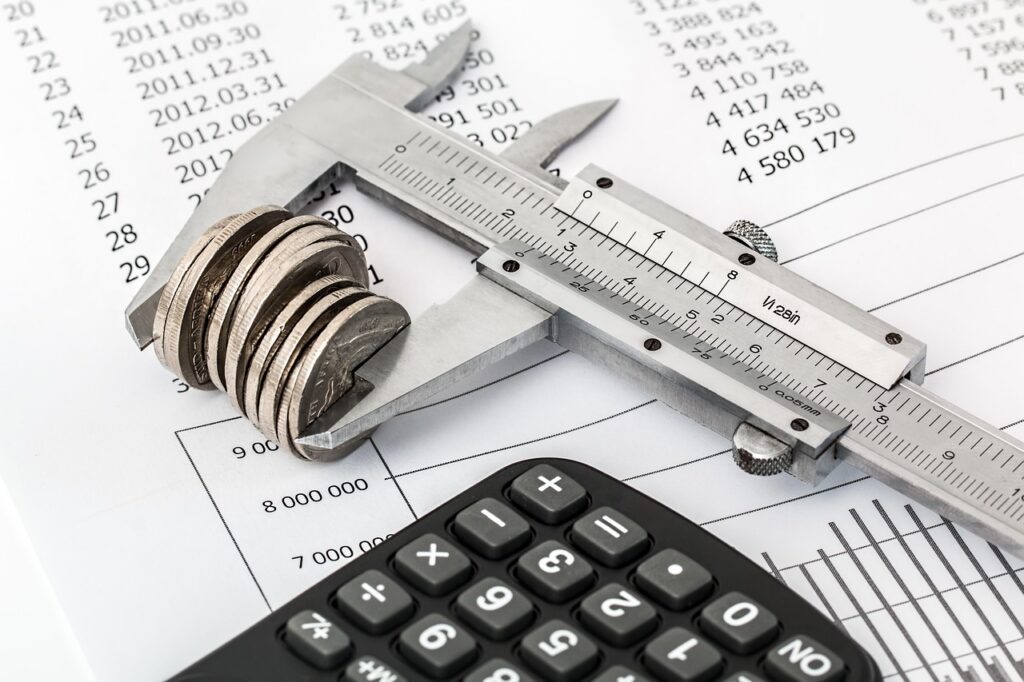 Calculator and bank statements used to track daily MCA debits against cash flow