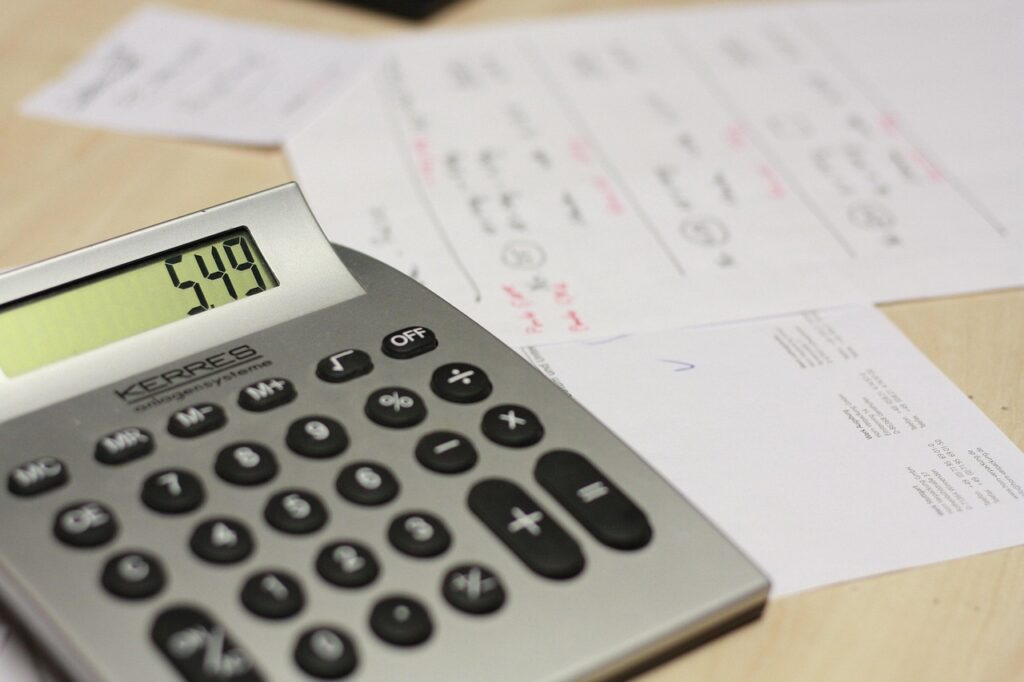 Calculator and stack of invoices on a farm stand table