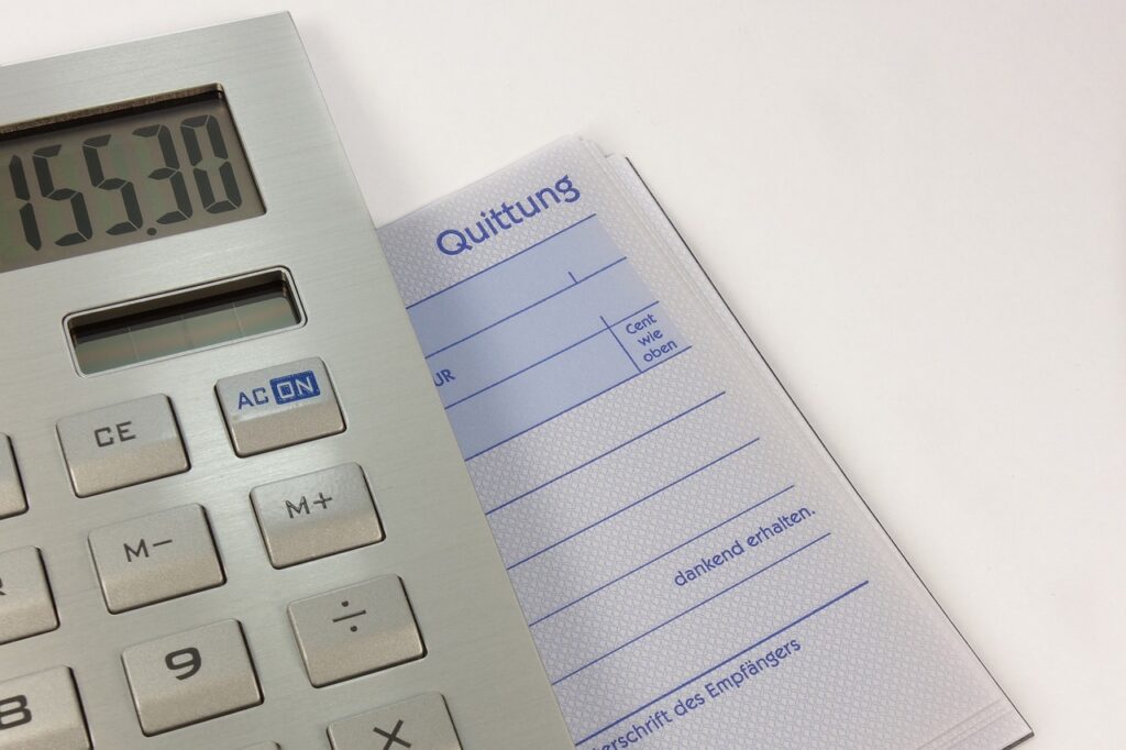 Calculator and parts invoices on an auto repair shop office desk