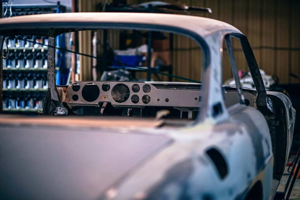 Multiple cars on lifts in a busy auto repair shop during summer rush