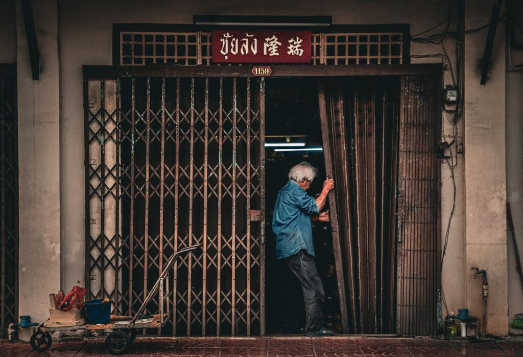 Business owner talking on the phone in a warehouse doorway at sunrise