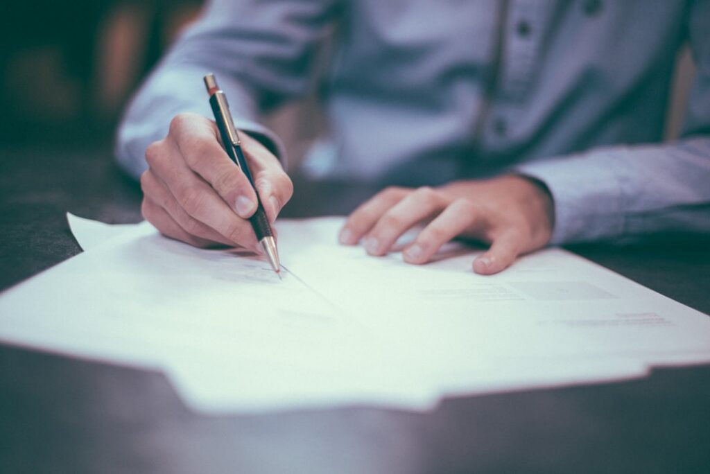 Close-up of a business owner signing a legal document