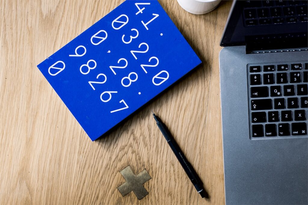Calculator and stack of pool maintenance invoices on a desk