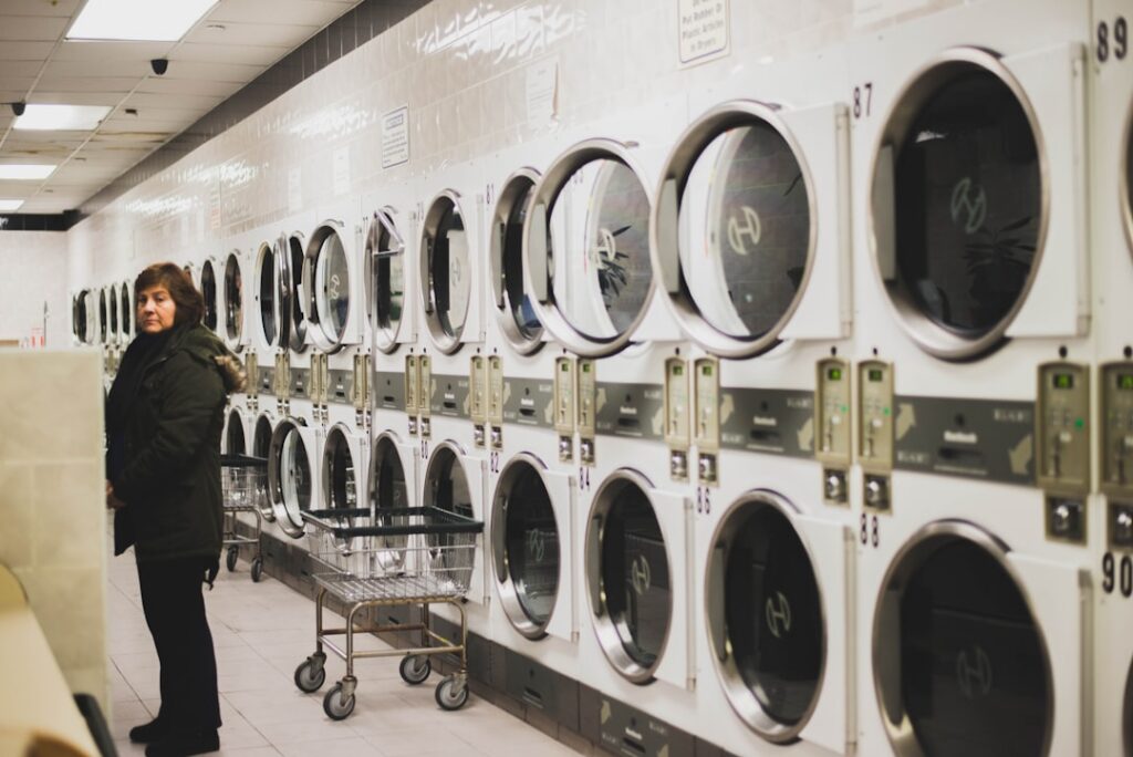 Laundromat owner checking coin-operated washing machines