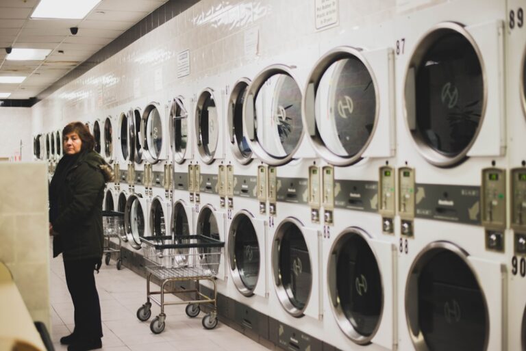 Laundromat owner checking coin-operated washing machines