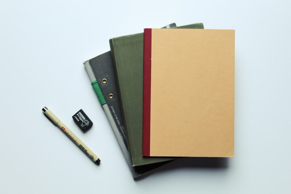 A stack of unpaid bills and file folders on a cluttered office desk