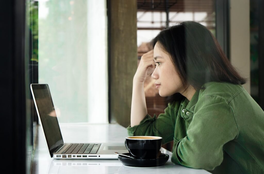 Small business owner checking bank account balance on a laptop at home