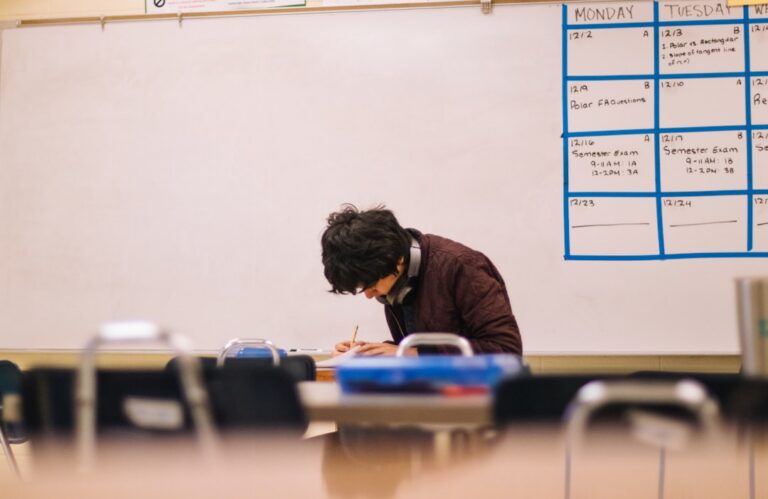 Tutoring center owner reviewing paperwork at an empty desk before the school year starts