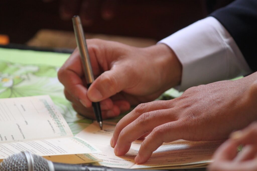 Close-up of hands signing a banking agreement document