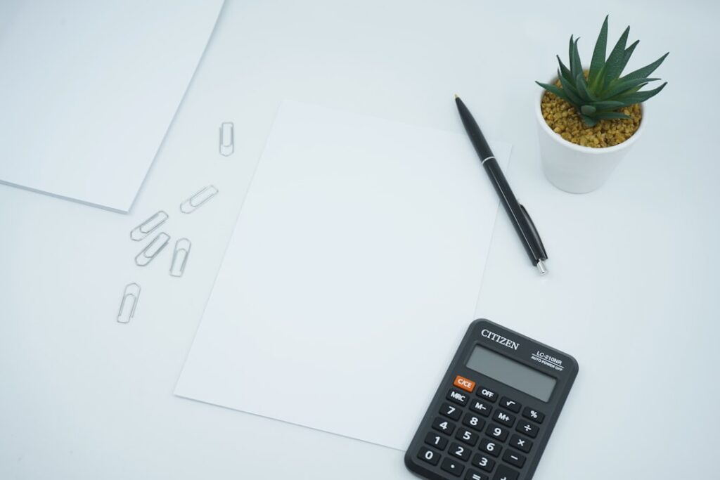 Business owner calculating daily payments against revenue with a calculator and receipts