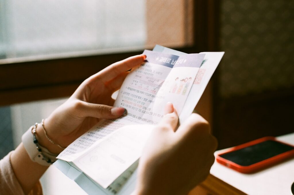 Close-up of hands calculating financing costs with a calculator and stack of receipts