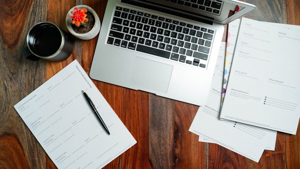 Stack of signed loan and contract paperwork with a pen on a desk