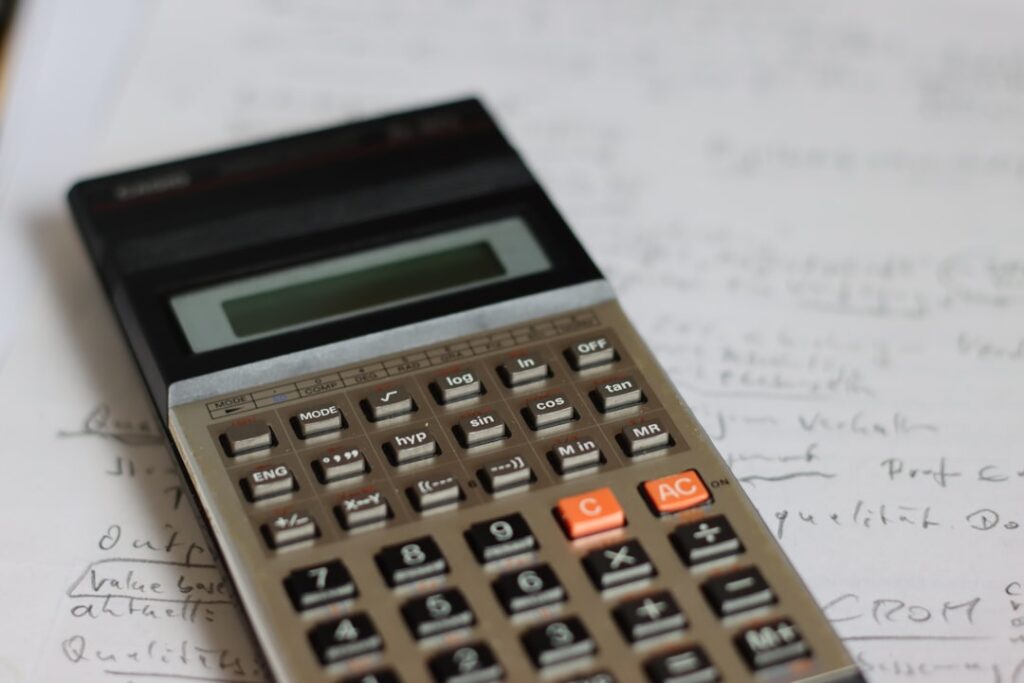 Calculator and bank statement illustrating a merchant cash advance holdback calculation