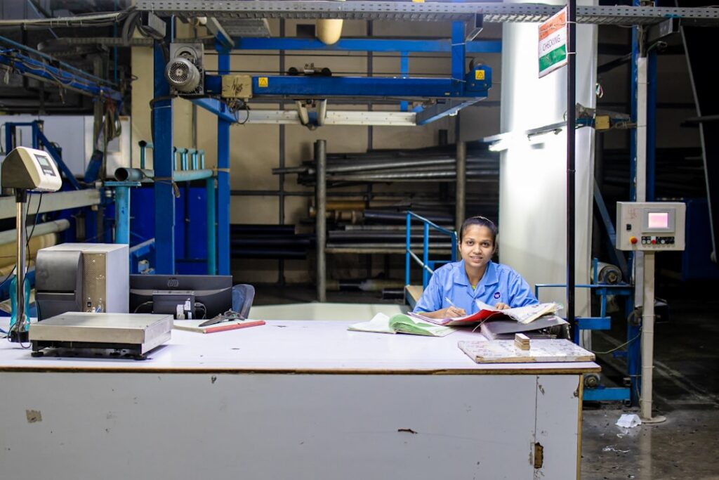 Print shop owner reviewing paperwork next to a commercial printer