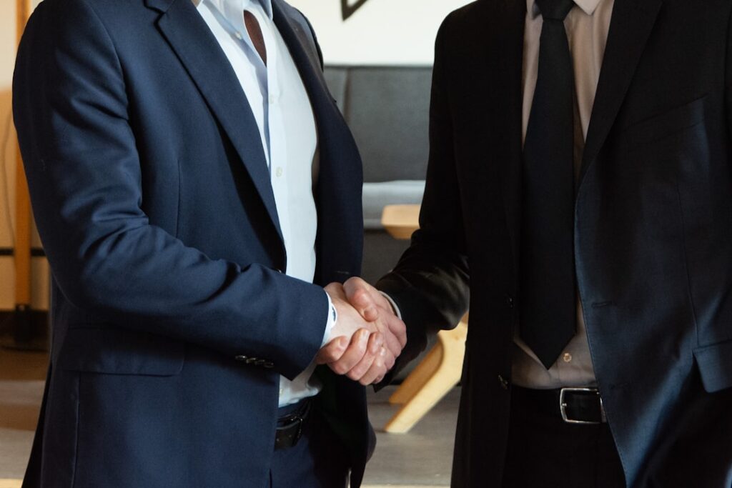 Two business professionals shaking hands after reaching a settlement agreement