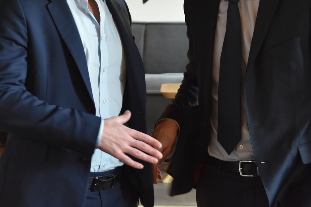 Business owner and advisor shaking hands after reaching a settlement agreement