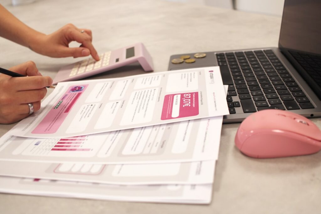 Small business owner calculating daily expenses with a calculator and receipts