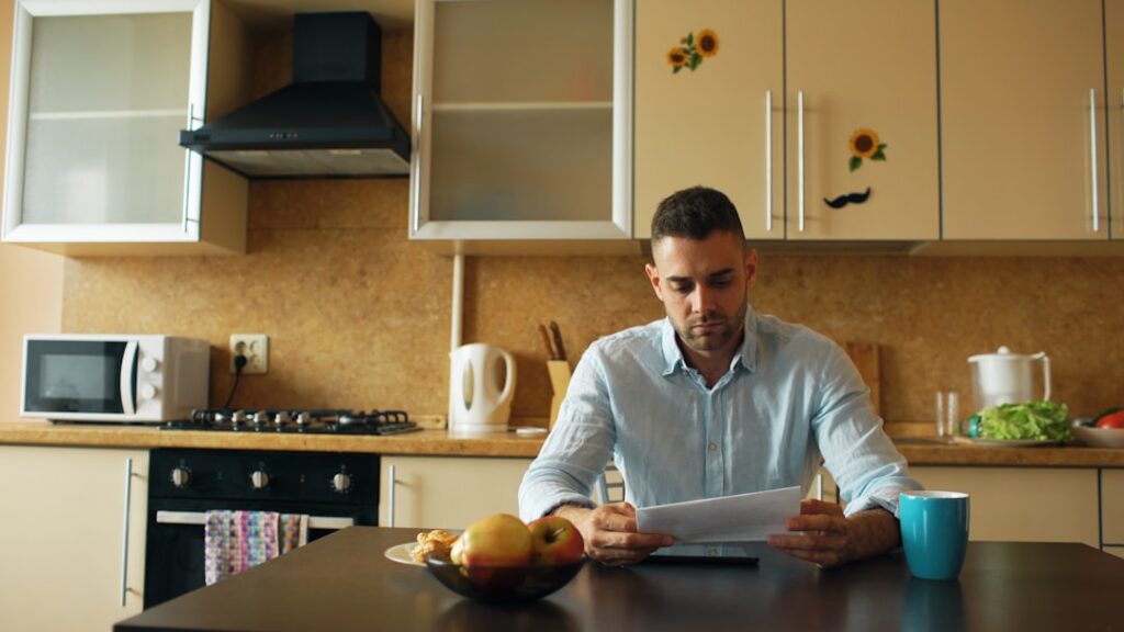 Business owner reviewing stacked bills late at night