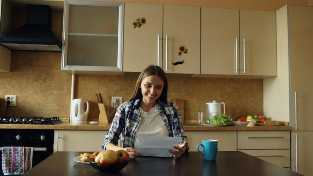 Business owner anxiously checking phone at a kitchen table early in the morning