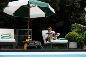 Pool service technician testing water chemistry at a residential pool during peak summer season