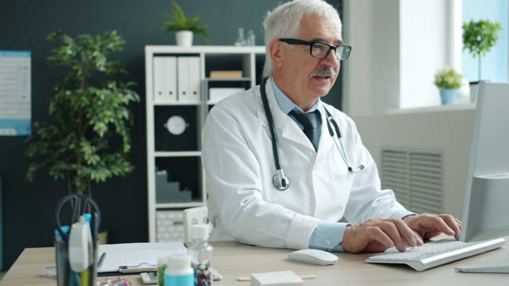 Medical billing administrator processing insurance claims at a computer