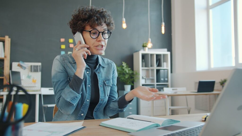 Small business owner on a phone call while reviewing financial documents