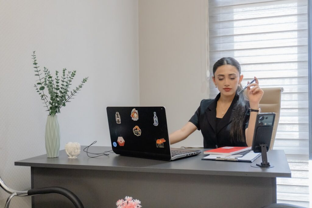 Freight broker reviewing shipping invoices and carrier payments at a desk