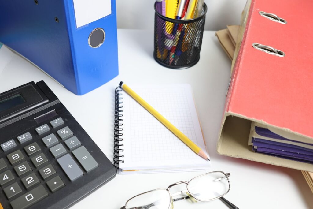 Calculator and printed invoices spread across a small business office desk